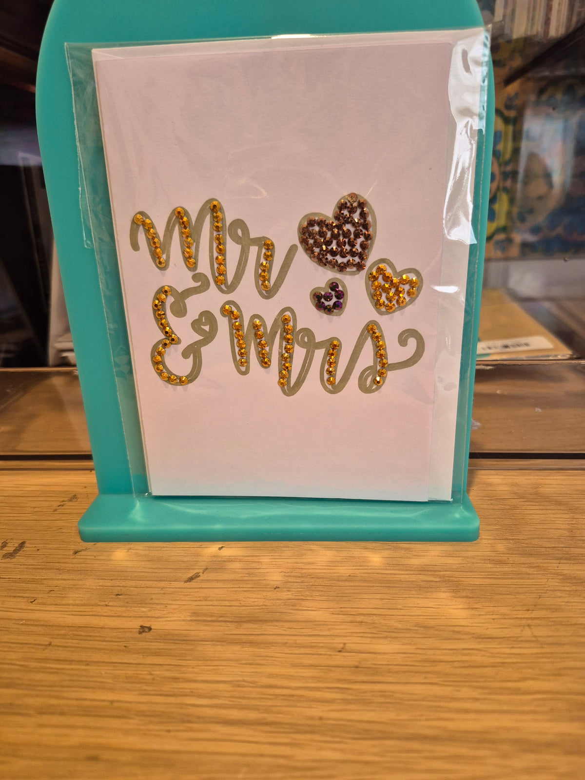 White Mr and Mrs wedding card with gold-coloured sparkling lettering and three embellished hearts