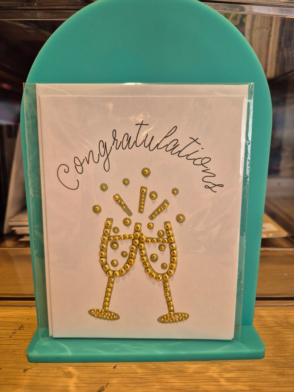 White congratulations card with gold-coloured sparkling champagne glasses