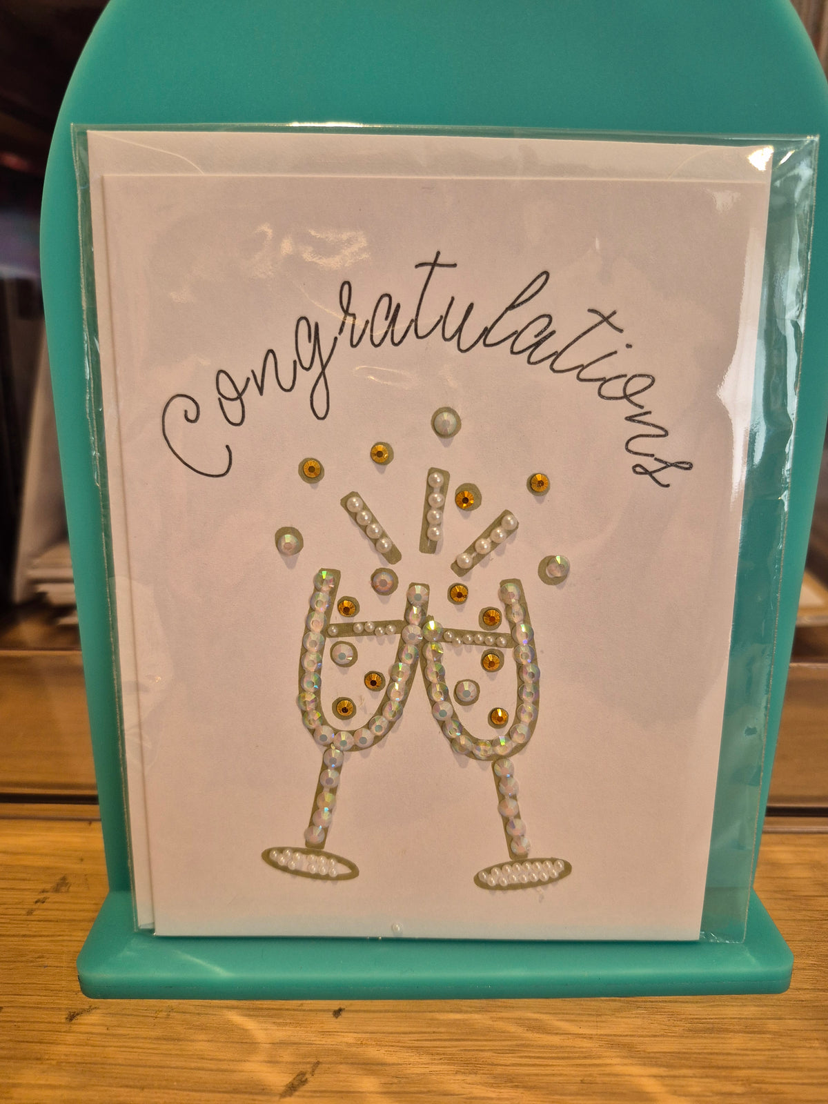 White congratulations card with sparkling pale champagne glasses and gold-coloured accents