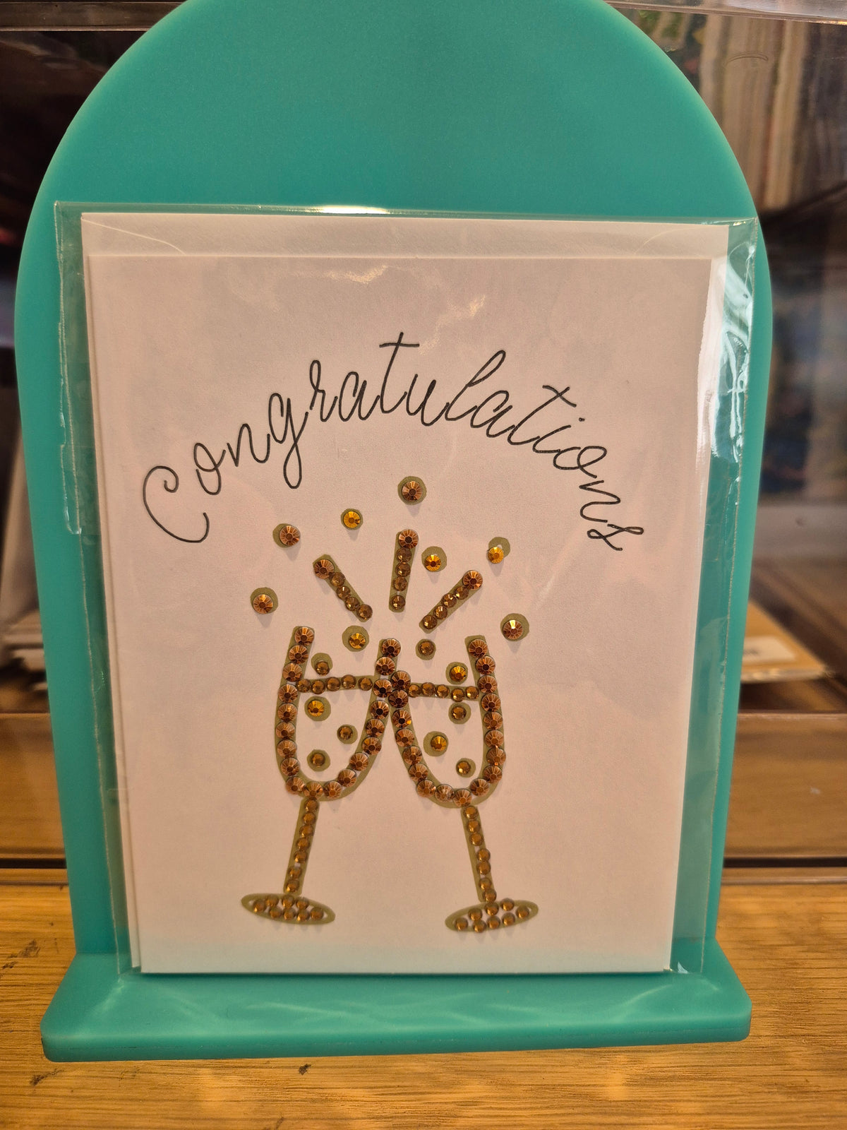 White congratulations card with bronze-toned sparkling champagne glasses