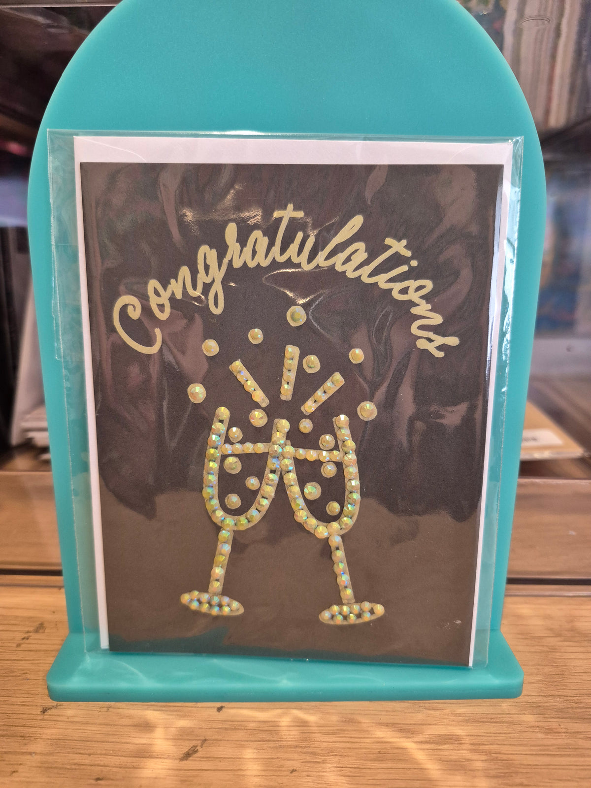 Dark congratulations card with pale sparkling champagne glasses and lettering