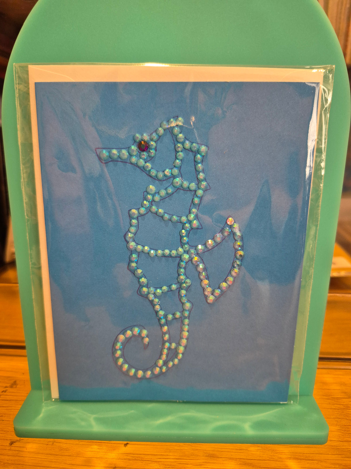 Blue greeting card featuring a seahorse outlined in pale shimmering embellishments