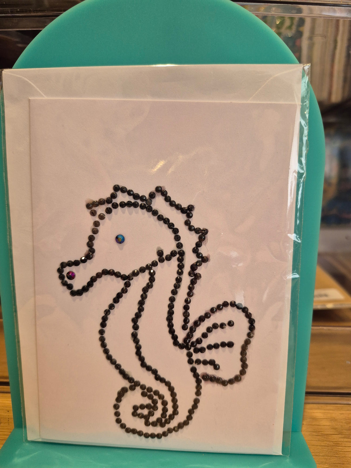 White greeting card featuring a seahorse outlined in dark sparkling embellishments